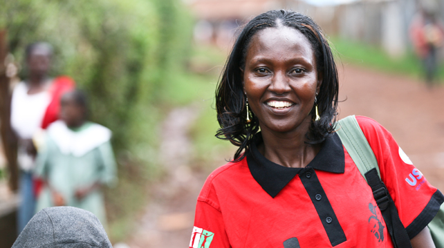 Camilla, a community health worker from Nairobi, smiles as she works